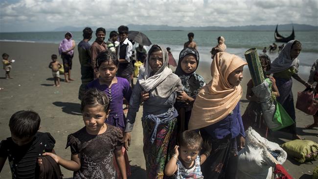 Rohingya Muslim refugees walk on the Bangladeshi shoreline of the Naf River after crossing the border from Myanmar in Teknaf on September 30, 2017. (Photo by AFP)