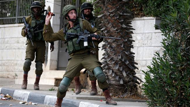 A member of the Israeli forces throws a tear gas canister towards Palestinian protesters during clashes in the West Bank city of Ramallah on October 6, 2017. (Photo by AFP)
