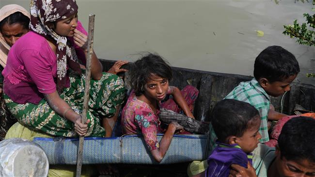 Rohingya refugees arrive on a boat after crossing Naf River from Myanmar into Bangladesh in Whaikhyang on October 9, 2017. (Photo by AFP)
