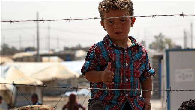 A displaced Iraqi boy, who fled the fighting in the region of Mosul, gestures to the camera at the Debaga camp, east of Makhmur in northern Iraq, on August 17, 2017. (Photo by AFP)
