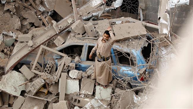 A Yemeni man reacts on the rubble of houses destroyed in a Saudi-led coalition air strike in Yemen