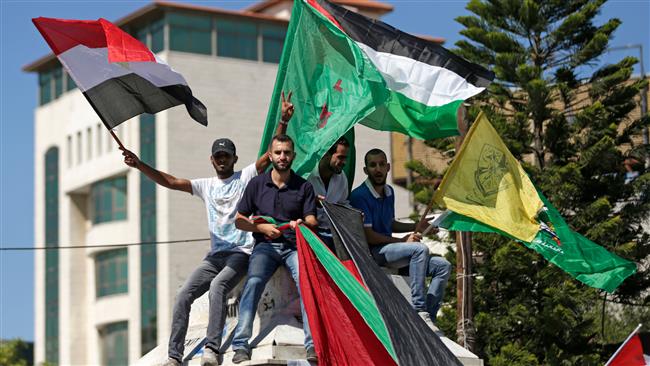 People wave the flags of Palestine, the Fatah party and Egypt as they gather in Gaza City on October 12, 2017 to celebrate after rival Palestinian factions Hamas and Fatah reached an agreement on ending a decade-long split. (Photo by AFP)
