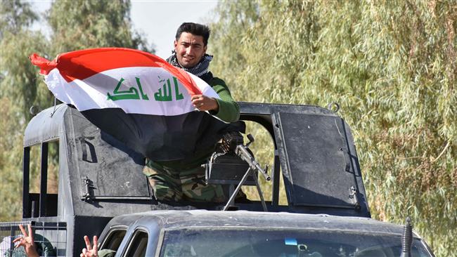 An Iraqi fighter loyal to the federal government waves the national flag from a turret atop a truck on a road in the region of Altun Kupri, about 50 kilometers (30 miles) from Erbil on October 20, 2017. (Photo by AFP)
