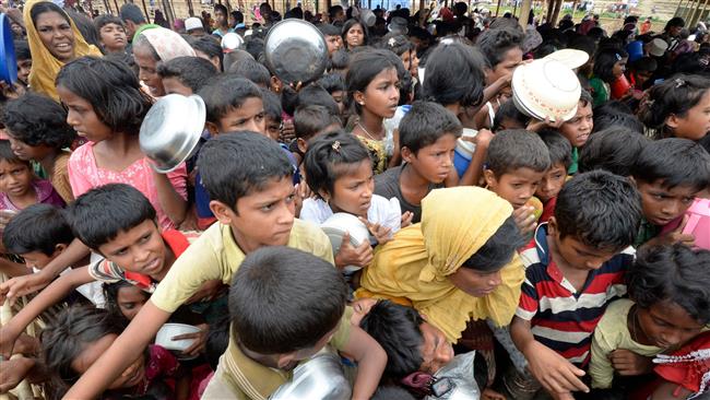Rohingya Muslim refugees wait to receive food distributed by a Turkish aid agency at Thaingkhali refugee camp in Ukhia, Bangladesh, on October 21, 2017. (Photo by AFP)
