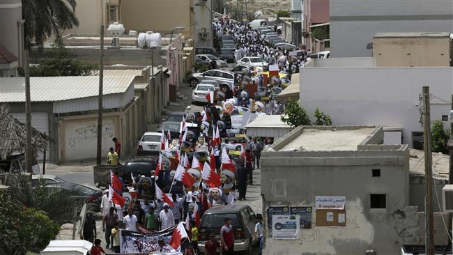 Bahraini anti-government protesters wave national flags and hold up images of jailed political leaders during a protest after midday prayers in Diraz, Bahrain, May 8, 2015. (Photo by AP)
