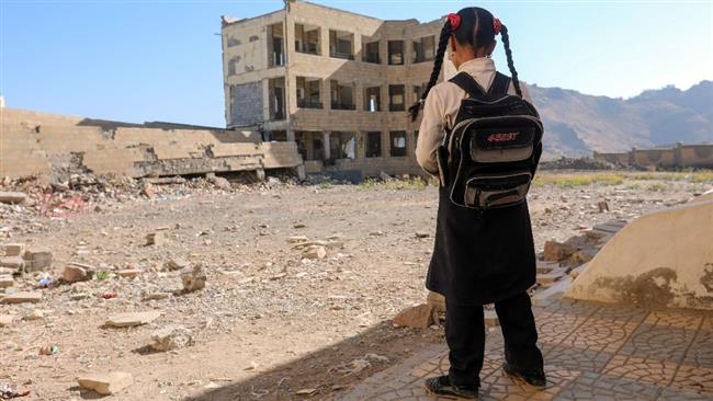 This file photo taken on March 16, 2017 shows a Yemeni schoolgirl standing outside a school, that was damaged in an airstrike in the southern Yemeni city of Ta’izz. (Photo by AFP)
