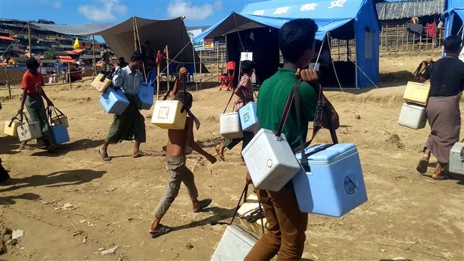 Rohingya volunteers carry ice boxes with cholera vaccines at the Thangkhali refugee camp in Bangladesh