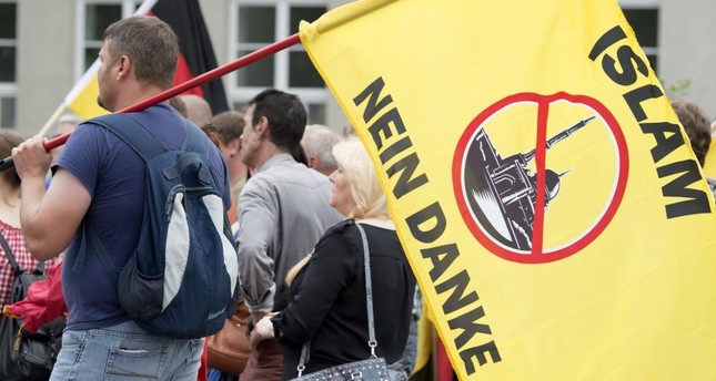 A supporter of the right-wing Patriotic Europeans say NO, holds a flag reading: "Islam, No Thanks," during a rally in Erfurt, Germany, June 4, 2016.
