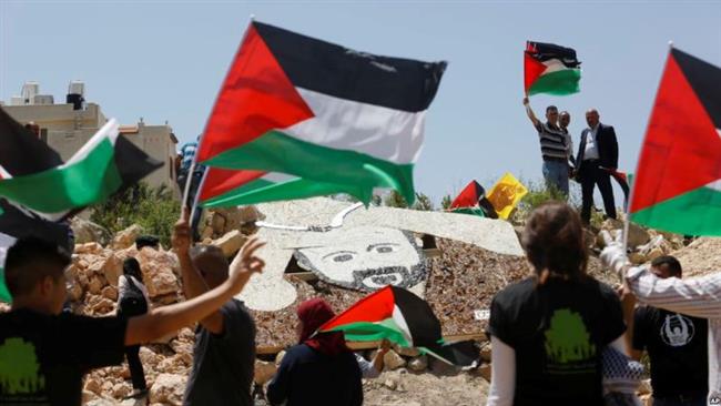 Palestinian activists stand around a 5x4 meter (16.5x13 feet) mosaic portrait of Marwan Barghouti near an Israeli military installation in the West Bank city of Ramallah, May 9, 2017. (Photo by AP)
