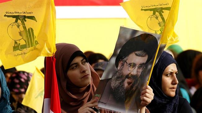 Lebanese women wave Hezbollah flags while holding a picture of the movement