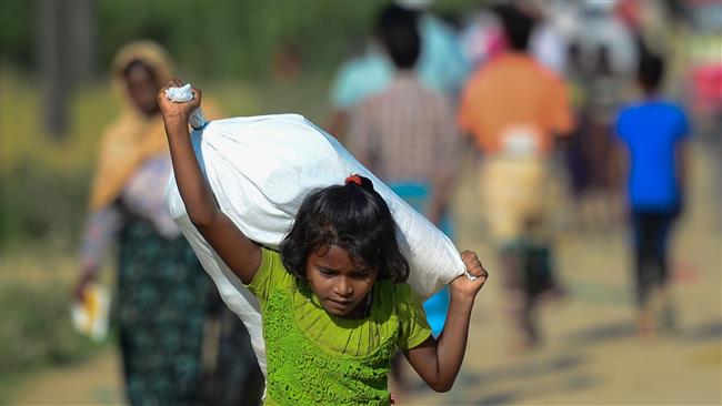 A Rohingya Muslim refugee child carries relief aid through the Balukhali refugee camp in the Ukhia district of Bangladesh, November 20, 2017. (Photo by AFP)
