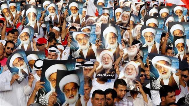 In this file photo, anti-regime protesters hold posters of Shia cleric Sheikh Isa Qassim during a protest organized by Bahrain