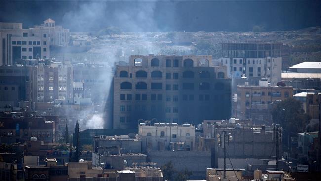 Smoke billows behind a building in the Yemeni capital Sana