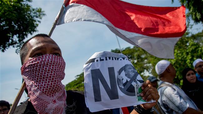 An Indonesian protester holds a placard during a protest in front of the US embassy in Jakarta on December 8, 2017. (Photo by AFP)
