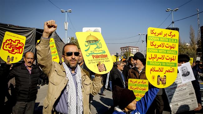 Iranian protesters wave placards denouncing the United States and the Israeli regime during a demonstration in the capital, Tehran, after Friday prayers on December 8, 2017 against US President Donald Trump