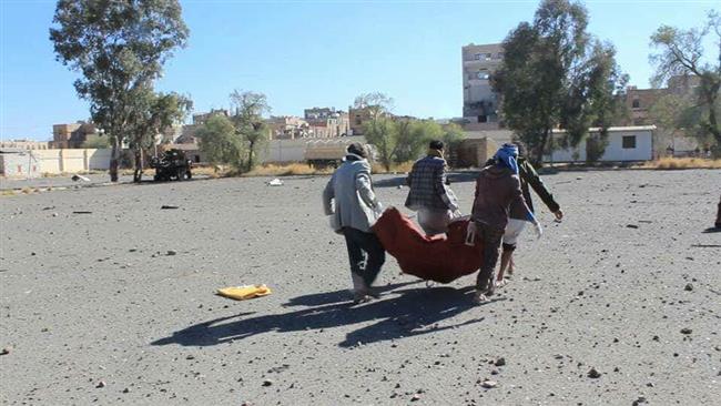 This photo taken from Yemeni media reports shows people carrying a victim of a deadly Saudi air raid on military police HQ in Sana