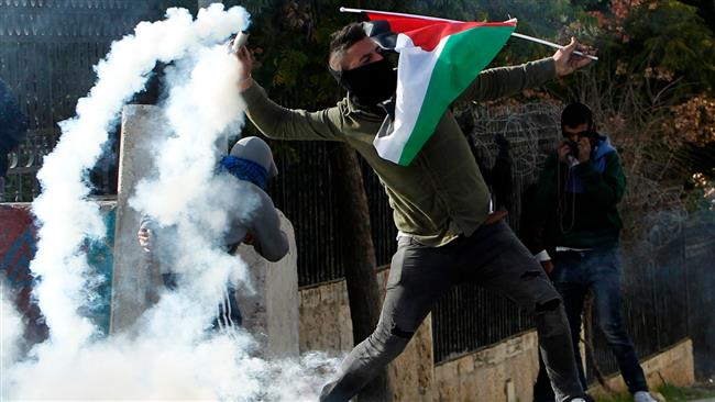 A Palestinian protester throws back a tear gas canister towards Israeli forces during clashes in the West Bank city of Bethlehem on December 10, 2017. (Photo by AFP)
