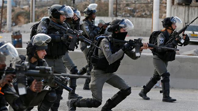 Israeli forces take aim as Palestinian protestors gather near the West Bank checkpoint of Qalandia, on the outskirts of Ramallah, on December 15, 2017. (Photo by AFP)
