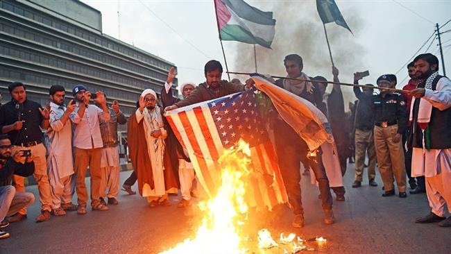 Pakistani activists burn US and Israeli flags during an anti-Trump rally in Karachi on December 10, 2017. (Photo by AFP)
