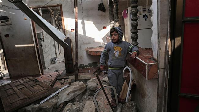 A Palestinian child walks in his house that was damaged in an Israeli airstrike on a nearby Hamas base, in Khan Yunis town in the southern Gaza Strip on December 13, 2017. (Photo by AFP)
