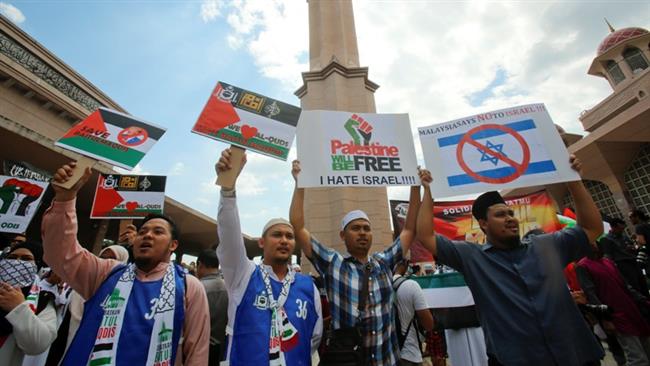 People hold placards that read, "Palestine will be Free" and "Anti-Israel" during a rally at the Putra Mosque in Putrajaya, Malaysia, December 22, 2017. (Photo by AP)
