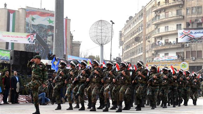 Syrian government soldiers march in formation during a rally celebrating the retaking of the northern Syrian city of Aleppo, in its square of Saadallah al-Jabiri on December 21, 2017. (Photo by AFP)
