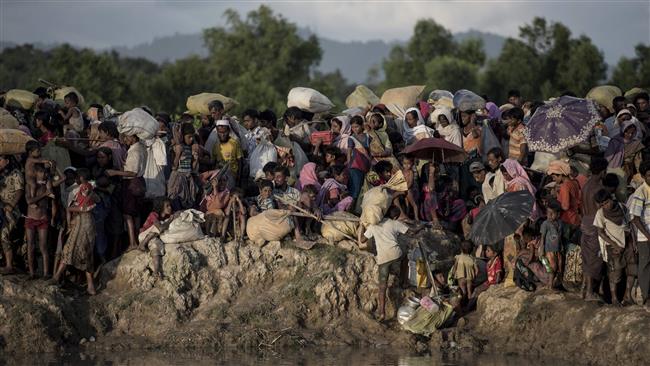 The photo taken on October 9, 2017 shows Rohingya Muslim refugees waiting after crossing the Naf river from Myanmar into Bangladesh in Whaikhyang. (Photo by AFP)
