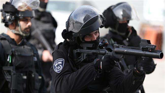 A member of the Israeli security forces aims his tear-gas launcher while patrolling a street where a home was demolished in a refugee camp in East Jerusalem al-Quds on December 5, 2017. (AFP photo)
