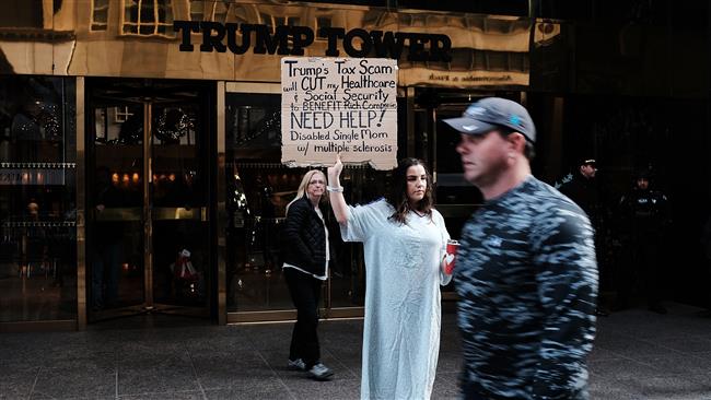 A woman, who has multiple sclerosis (MS) and fears for her finances, holds a protest outside of Trump Tower over the Republican administration’s proposed tax cut which many economists predict will benefit the wealthy at the expense of the poor and middle class on November 30, 2017 in New York City. (Photo by AFP)
