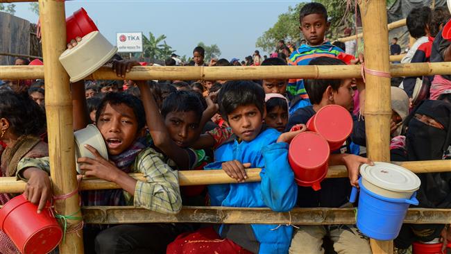 Rohingya Muslim refugees wait for food aid at the Thankhali refugee camp in Bangladesh’s Ukhia district, January 12, 2018. (Photo by AFP)
