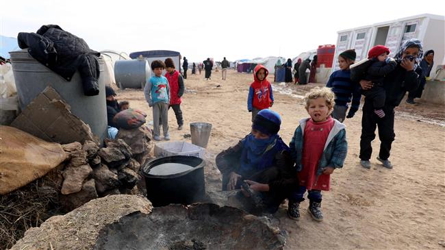 Displaced Syrians, from the eastern city of Dayr al-Zawr and Raqqa hwho were forced to leave by the war against Daesh, prepare food at the Ain Issa camp on December 18, 2017. (Photo by AFP)