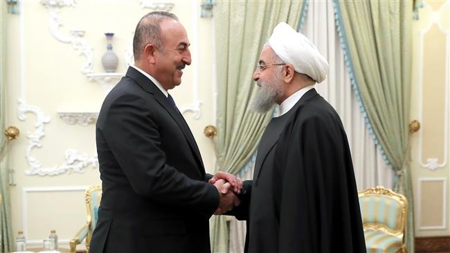 Iranian President Hassan Rouhani (R) and Turkish Foreign Minister Mevlut Cavusoglu shake hands prior to their meeting in Tehran on February 7, 2018. (Photo by president.ir)
