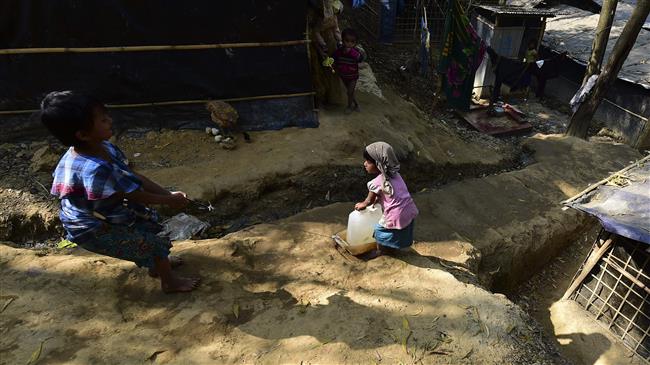 Rohingya refugee children pull up a water container at Kutupalong refugee camp in Bangladesh