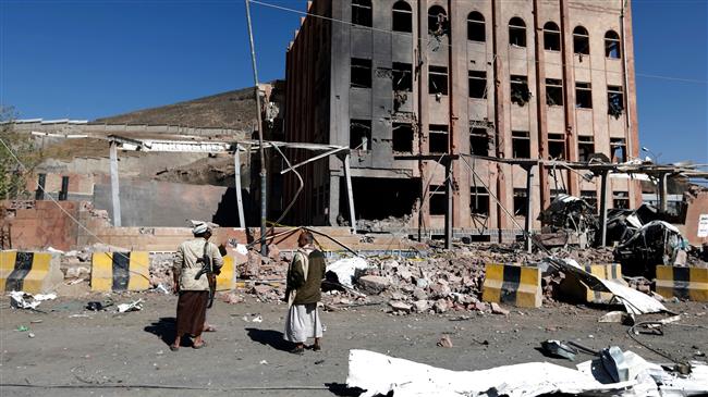 A picture taken on February 5, 2018, shows armed men gathering around the Yemeni criminal investigations unit in the capital Sana’a, a day after it was hit in a Saudi air raid. (Photo by AFP)
