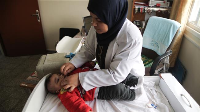 A Palestinian doctor treats a sick child at a clinic in al-Nusirat refugee camp in the Gaza strip on January 17, 2018. (AFP photo)

