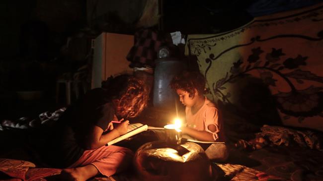 Palestinian children do their homework during a power cut in Gaza City, on September 11, 2017. (Photo by AFP)
