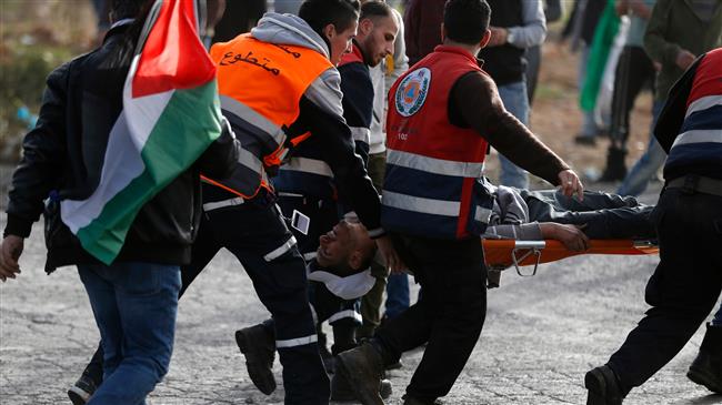 Palestinian demonstrators carry a wounded person during clashes with Israeli forces near the Israeli settlement of Beit El in the Israeli-occupied West Bank, on February 16, 2018. (Photo by AFP)
