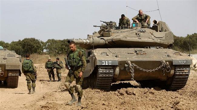 In this file picture, Israeli soldiers stand guard with their tank along the border between the Gaza Strip and the occupied Palestinian territories. (Photo by the Times of Israel)
