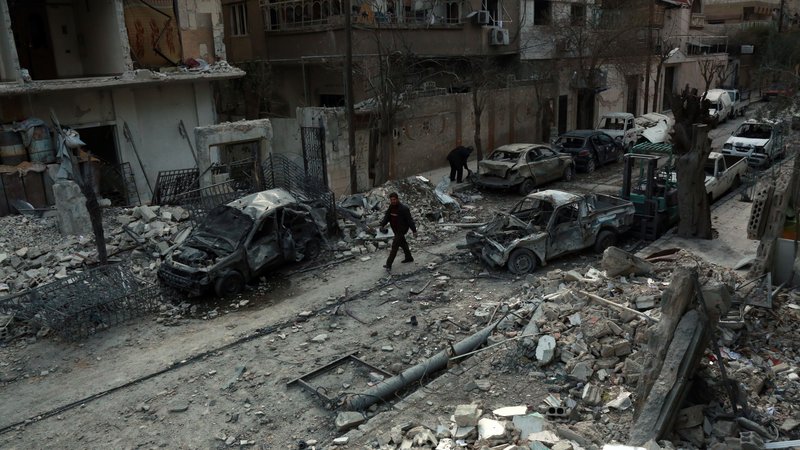 A man walks next to damaged buildings following air strikes today in the rebel-held
