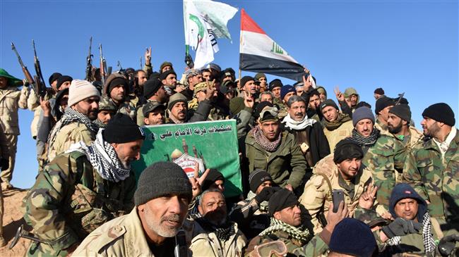 Members of the Imam Ali Division, one of the groups fighting within the Popular Mobilization Units (Hashd al-Sha’abi), celebrate after Iraqi Prime Minister Haider al-Abadi declared victory in the war against Daesh, in a location about 80 kilometers (about 50 miles) along the Iraqi-Syrian border west of the border town of al-Qa’im on December 9, 2017. (Photo by AFP)
