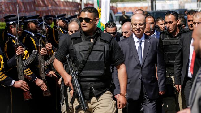 Palestinian Prime Minister Rami Hamdallah (2nd-R), escorted by his bodyguards, is greeted by police forces of the Palestinian resistance movement Hamas (L) upon his arrival in Gaza City on March 13, 2018. (AFP photo)
