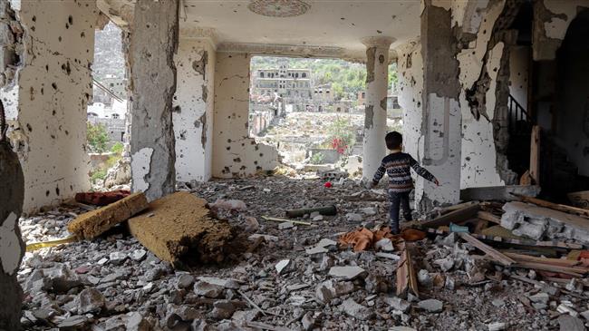 A photo taken on March 18, 2018, shows a Yemeni child walking in the rubble of a building that was destroyed in an airstrike in the southern Yemeni city of Ta