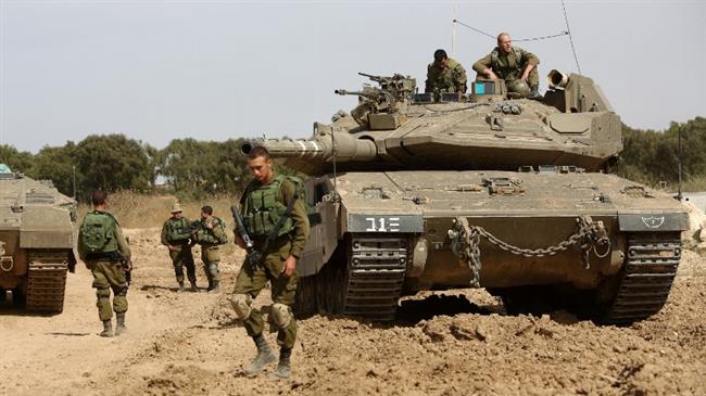 Israeli soldiers stand guard with their tank along the border between the occupied territories and the Gaza Strip near the southern Israeli kibbutz of Nahal Oz on May 4, 2016. (Photo by AFP)
