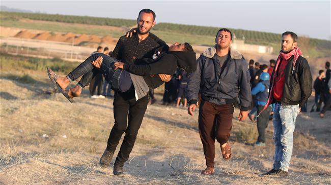 A Palestinian protester carries an injured comrade during a protest, in which Israeli forces used live fire from across a buffer zone into the Gaza Strip, east of Gaza City, on April 1, 2018. (Photo by AFP)
