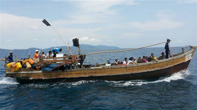 This handout photo released and taken by the Royal Thai Army on April 1, 2018, shows a wooden boat carrying Rohingya refugees being guided by Royal Thai Navy personnel (seen standing in dark outfit on the bow) as it sails towards Thailand-Malaysia sea boundary. (Photo by AFP)

