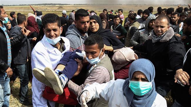 An injured Palestinian woman is carried by protesters as they run for cover during clashes with Israeli forces, east of teh city of Khan Yunis, in the southern Gaza Strip on March 30, 2018. (Photo by AFP)
