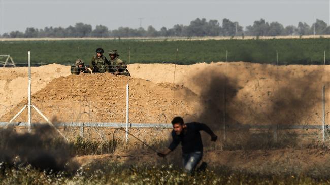 Israeli forces aim their weapons towards Palestinian demonstrators on March 31, 2018 during clashes in occupied West Bank city of Hebron (al-Khalil). (Photo by AFP)