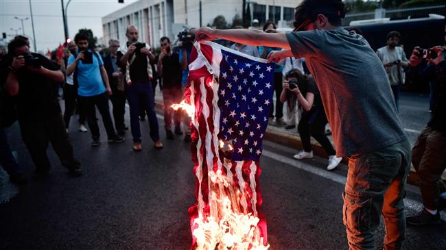 A protester burns an US flag outside the US Embassy in Athens on April 14, 2018 during a rally against US military intervention in Syria.