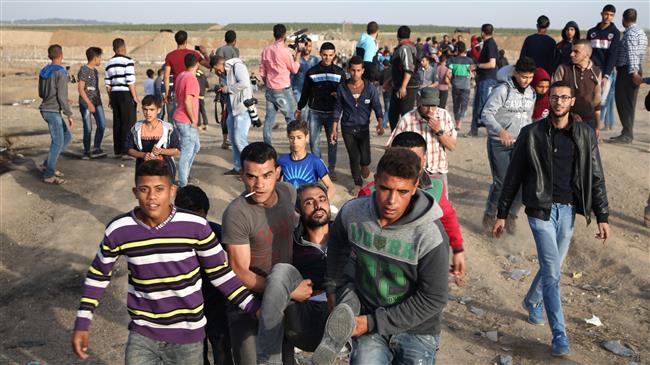 Palestinians carry a wounded man during clashes with Israeli forces east of Gaza City, April 17, 2018. (Photo by AFP)
