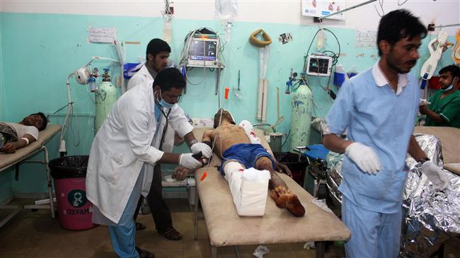 Yemeni doctors treat a man wounded in Saudi air raids that hit a Bedouin tent in Rahal, Sa